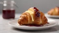 Delicious croissant topped with butter and jam on white plate
