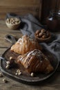 Delicious croissants with chocolate and nuts on wooden table