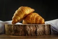 Delicious croissants on wooden trunk, with white towel around