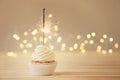 Delicious cupcake with sparkler on light wooden table Royalty Free Stock Photo