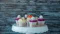 Delicious cupcakes with white cream decorated with ripe strawberries on a gray blue background