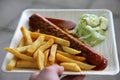 Currywurst curry sausage with french fries and cucumber salad and tomato ketchup