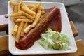 Currywurst curry sausage with french fries and cucumber salad and tomato ketchup