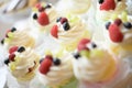 Delicious custard and berries cupcakes, assortment of sweets and cakes display at a candy buffet