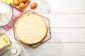 Delicious cut sponge cake and ingredients on white wooden table, flat lay. Space for text Royalty Free Stock Photo