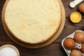 Delicious cut sponge cake and ingredients on wooden table, flat lay Royalty Free Stock Photo