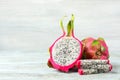 Delicious cut and whole dragon fruits pitahaya on light wooden table. Space for text