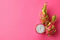 Delicious cut and whole dragon fruits pitahaya on pink background. Space for text