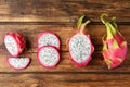 Delicious cut and whole dragon fruits pitahaya on wooden table