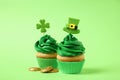 Delicious decorated cupcakes and coins on green background. St. Patrick`s Day celebration