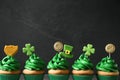 Delicious decorated cupcakes on dark grey, space for text. St. Patrick`s Day celebration