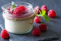 Delicious dessert panna cotta with raspberry sauce, fresh raspberries and mint on black slate background Royalty Free Stock Photo
