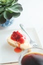 Delicious with dessert a piece of cherry cheesecake and black coffee on white tone wooden table Royalty Free Stock Photo