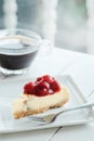 Delicious with dessert a piece of cherry cheesecake and black coffee on white tone wooden table Royalty Free Stock Photo