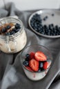 Delicious dessert: tiramisu in a glass jar and natural yogurt in a glass cup with fresh berries, strawberries and blueberries. Royalty Free Stock Photo