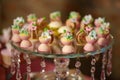 Dessert variety of playful or themed bite-sized cakes shaped as small white and pink chocolate cups with icing sugar flowers