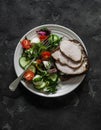Delicious diet lunch - turkey sandwich and fresh vegetable salad on a dark background, top view Royalty Free Stock Photo
