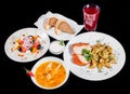 Delicious dinner table with baked chicken breast and potatoes, fresh greek salad, chicken soup, bread and compote