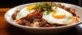 A tasty dish of fried egg, meat, and rice on a wooden table Royalty Free Stock Photo