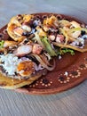 Delicious dish of Sopes and seafood tostadas that are a fried tortilla with beans, shrimp and octopus on top Royalty Free Stock Photo