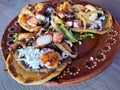 Delicious dish of Sopes and seafood tostadas that are a fried tortilla with beans, shrimp and octopus on top Royalty Free Stock Photo