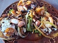 Delicious dish of Sopes and seafood tostadas that are a fried tortilla with beans, shrimp and octopus on top Royalty Free Stock Photo