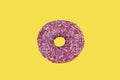 Delicious donut on a yellow background. doughnut topped with icing sugar and sprinkles. bright colored crumpet