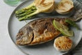Delicious dorado fish with vegetables served on table, closeup