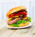 Double tasty hamburger with beef cutlet, fresh vegetables and cheese Royalty Free Stock Photo