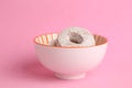 Delicious doughnuts covered in  sugar powder in the bowl on the pink background Royalty Free Stock Photo