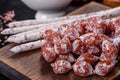 Delicious dry sausage with walnuts on a concrete table. Dry cured fuet sausage on a dark background Royalty Free Stock Photo