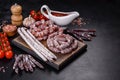 Delicious dry sausage with walnuts on a concrete table. Dry cured fuet sausage on a dark background Royalty Free Stock Photo