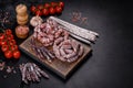 Delicious dry sausage with walnuts on a concrete table. Dry cured fuet sausage on a dark background Royalty Free Stock Photo