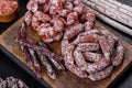 Delicious dry sausage with walnuts on a concrete table. Dry cured fuet sausage on a dark background Royalty Free Stock Photo