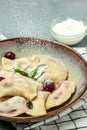 Delicious dumplings with cherries and cream sauce, Food recipe background. Close up, top view Royalty Free Stock Photo