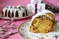 A delicious Easter cake - a ring in white icing on a pink table background next to willow branches and Easter eggs. Royalty Free Stock Photo