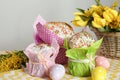 Delicious Easter cakes, dyed eggs and basket with flowers on table Royalty Free Stock Photo