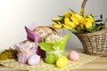 Delicious Easter cakes, dyed eggs and basket with flowers on wooden table Royalty Free Stock Photo