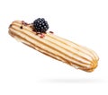 Delicious eclair with blackberry close-up on a white background