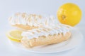 Delicious eclair on a plate and lemon