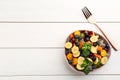 Delicious exotic fruit salad and fork on white wooden table, flat lay. Space for text Royalty Free Stock Photo