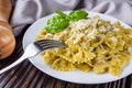 Delicious farfalle pasta with pesto sauce on wooden rustic background