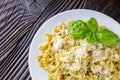 Delicious farfalle pasta with pesto sauce on wooden rustic background