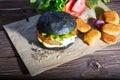 Delicious fast food. Tasty burger with bacon on table against black background. Space for text Royalty Free Stock Photo