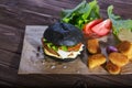 Delicious fast food. Tasty burger with bacon on table against black background. Space for text Royalty Free Stock Photo