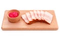 Delicious fat pork jowl bacon with horseradish sauce on wooden plate Royalty Free Stock Photo