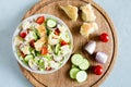 Delicious fattoush salad with bread pita, fresh vegetables and basil on plate on the wooden stand. Traditional middle eastern