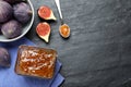 Delicious fig jam and fresh fruits on black table, flat lay. Space for text Royalty Free Stock Photo