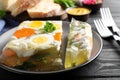 Delicious fish aspic served on black wooden table, closeup