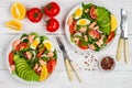 Delicious fish salad salmon or tuna with lettuce, tomatoes, red onion, eggs and avocado with dressing of olive oil , mustard and Royalty Free Stock Photo